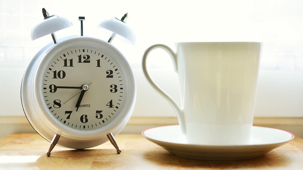 Alarm clock and coffee cup, the perfect way to wake up in a morning