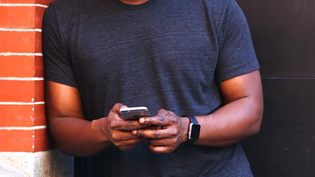 Man with iPhone securing Notes with Face ID or fingerprint