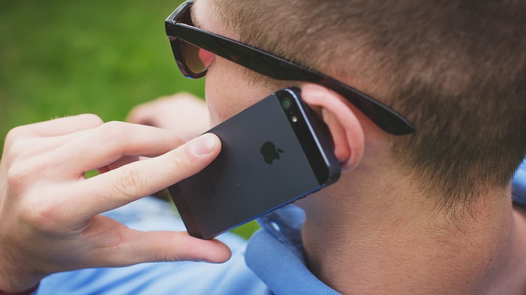 Man talking on an iPhone: Don't talk to scammers and junk sales calls, block them