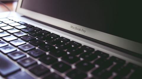 Close up photo of an Apple MacBook showing the keyboard and screen
