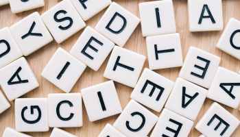 A collection of letter tiles scatters on a table.
