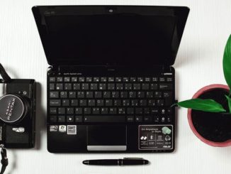 Laptop computer and camera on a desk. Are the files on the laptop backed up?